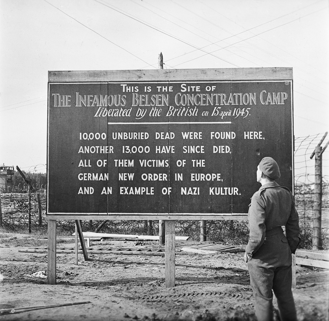Informationstafel am ehemaligen Lagereingang, 29. Mai 1945. Foto Sgt. Hewitt. Imperial War Museum, London, Photograph Archive, BU 6955