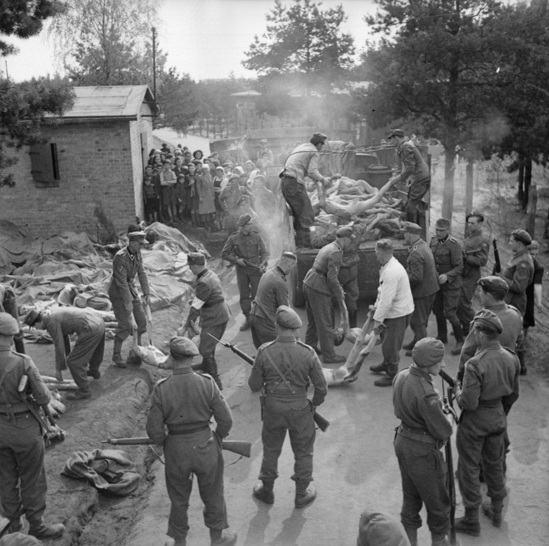 Arrested SS members carrying bodies, 17/18 April 1945. Photo by Sgt. Oakes. Imperial War Museum, London, Photograph Archive, BU 4025.