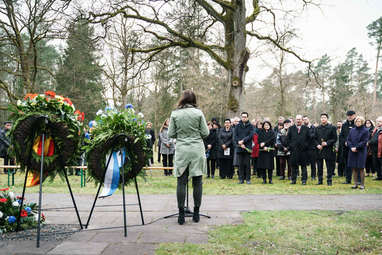 Gedenken auf dem Kriegsgefangenenfriedhof, Begrüßung Katja Seybold, stehend vor Publikum von hinten fotografiert